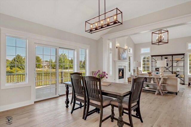 8806 Indiana Harbor Dr, Frankfort, IL 60423 - dining room with a chandelier, lofted ceiling, light wood finished floors, baseboards, and a glass covered fireplace