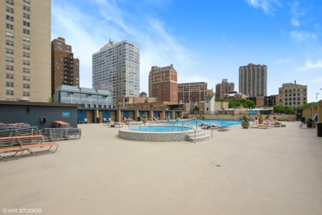 community pool with a skyline view and a patio