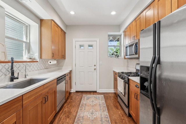 5140 N Albany Ave Unit 1, Chicago, IL 60625 - kitchen featuring appliances with stainless steel finishes, a sink, decorative backsplash, dark wood finished floors, and light countertops