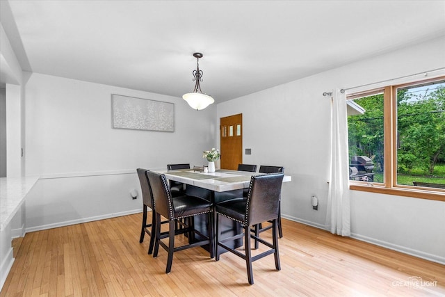 dining area with light wood-style flooring and baseboards