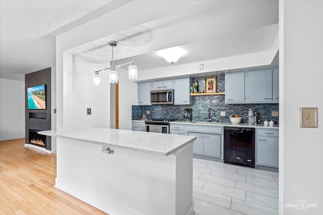 kitchen featuring appliances with stainless steel finishes, a sink, backsplash, and open shelves