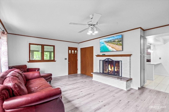 living area featuring ornamental molding, wood finished floors, a brick fireplace, and a ceiling fan