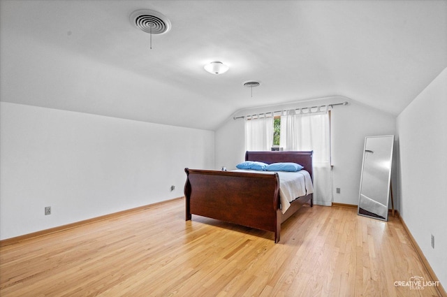 bedroom featuring vaulted ceiling, light wood finished floors, and baseboards