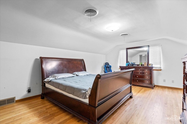 bedroom featuring light wood-style flooring, lofted ceiling, and baseboards
