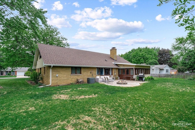 back of property featuring a fire pit, brick siding, a patio area, a chimney, and central AC