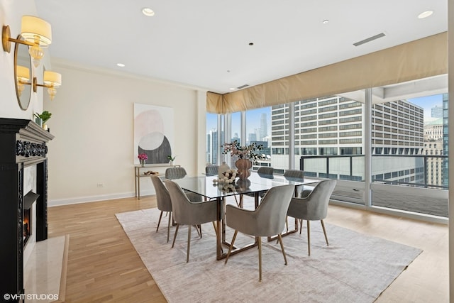 333 N Canal St Unit 2201, Chicago, IL 60606 - dining room featuring a skyline view, healthy amount of natural light, a fireplace, light wood-style flooring, and recessed lighting