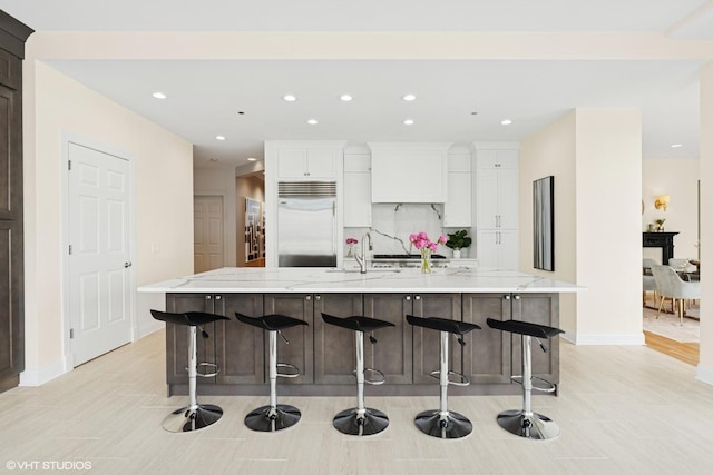 333 N Canal St Unit 2201, Chicago, IL 60606 - kitchen with built in refrigerator, recessed lighting, white cabinets, a large island with sink, and light stone countertops