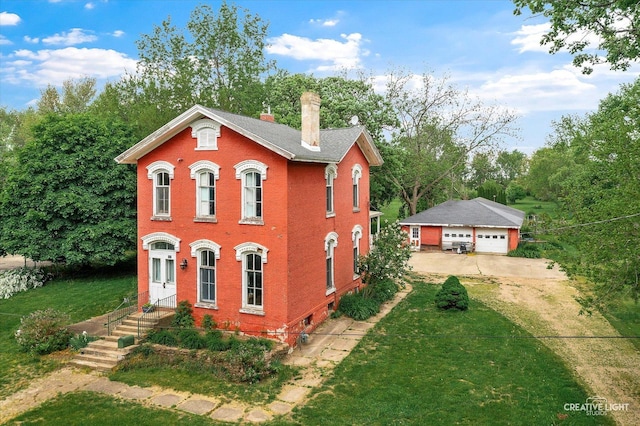730 E Main St, Amboy, IL 61310 - italianate-style house with a chimney, a detached garage, brick siding, a front yard, and an outdoor structure