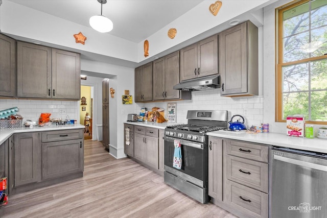 730 E Main St, Amboy, IL 61310 - kitchen with stainless steel appliances, under cabinet range hood, healthy amount of natural light, and decorative backsplash