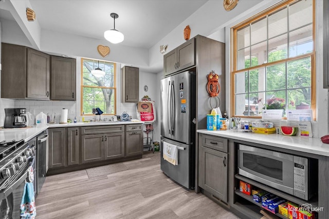 730 E Main St, Amboy, IL 61310 - kitchen with appliances with stainless steel finishes, decorative backsplash, light countertops, and light wood-type flooring