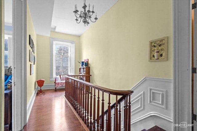 730 E Main St, Amboy, IL 61310 - corridor featuring an upstairs landing, a chandelier, wood finished floors, and wainscoting