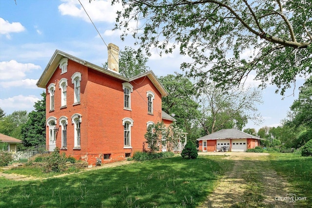 730 E Main St, Amboy, IL 61310 - view of home's exterior with a garage, a chimney, a lawn, and brick siding
