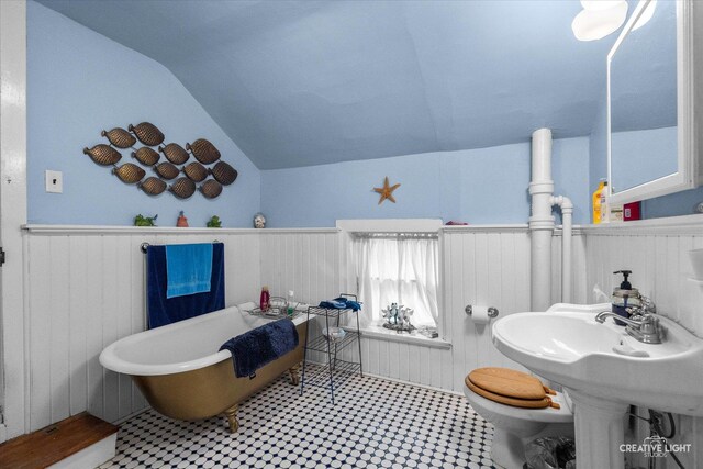 730 E Main St, Amboy, IL 61310 - full bath featuring vaulted ceiling, a freestanding tub, wainscoting, toilet, and tile patterned floors