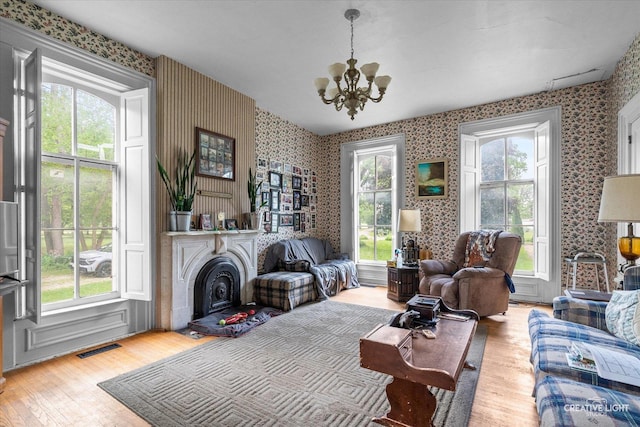 730 E Main St, Amboy, IL 61310 - living room with wallpapered walls, wood finished floors, a chandelier, and a fireplace with raised hearth