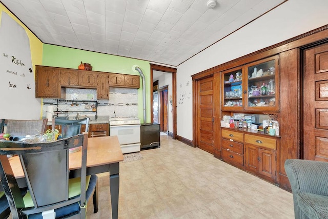 2655 S Millard Ave, Chicago, IL 60623 - kitchen featuring electric range, backsplash, and brown cabinetry