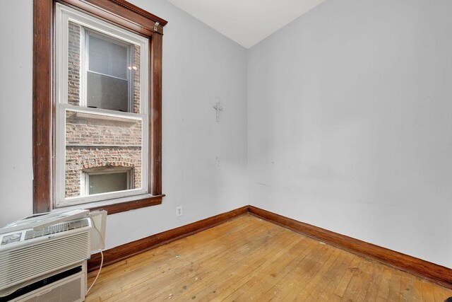 2655 S Millard Ave, Chicago, IL 60623 - unfurnished room featuring baseboards, hardwood / wood-style flooring, and a wall mounted air conditioner