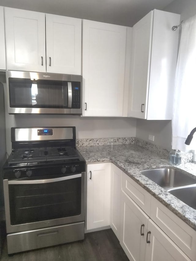1438 Maple Ave, Berwyn, IL 60402 - kitchen with appliances with stainless steel finishes, a sink, white cabinets, and dark wood-type flooring