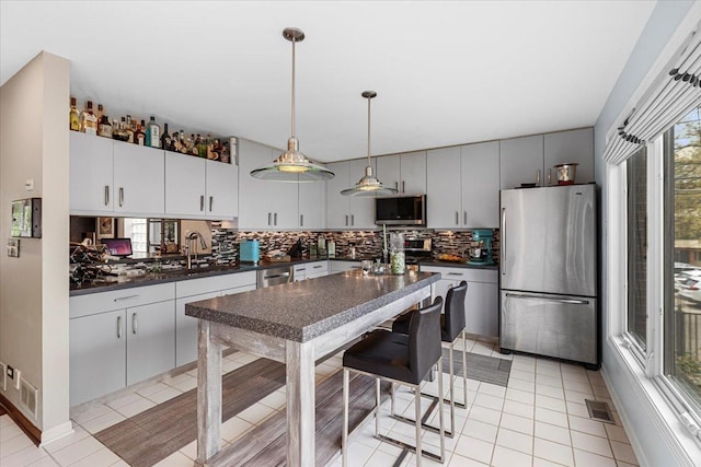 1162 W Farwell Ave, Chicago, IL 60626 - kitchen with appliances with stainless steel finishes, dark countertops, plenty of natural light, and decorative backsplash