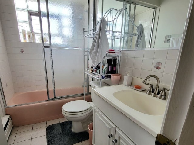 1509 Brown St Unit 11E, Des Plaines, IL 60016 - full bath featuring tile patterned floors, vanity, toilet, combined bath / shower with glass door, and tasteful backsplash