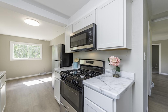 6008 240th Ave, Paddock Lake, WI 53168 - kitchen with stainless steel microwave, gas range oven, light wood finished floors, and white cabinets
