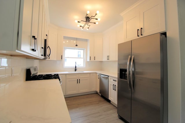 957 E Eagle St, Kankakee, IL 60901 - kitchen with stainless steel appliances, a sink, a chandelier, backsplash, and light countertops