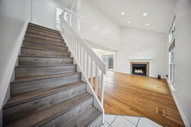 1242 N Knollwood Dr Unit 1242, Palatine, IL 60067 - stairs featuring high vaulted ceiling, a fireplace with flush hearth, recessed lighting, baseboards, and tile patterned flooring