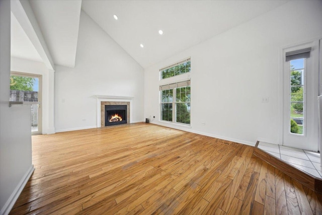 1242 N Knollwood Dr Unit 1242, Palatine, IL 60067 - unfurnished living room with high vaulted ceiling, light wood-style floors, a warm lit fireplace, recessed lighting, and baseboards
