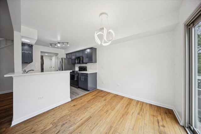 1242 N Knollwood Dr Unit 1242, Palatine, IL 60067 - kitchen featuring black appliances, light wood-style flooring, light countertops, baseboards, and a peninsula