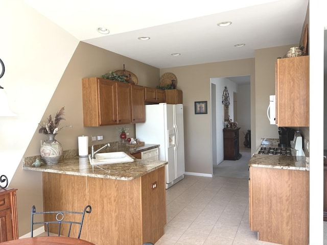 2026 Highbury Ln, Aurora, IL 60502 - kitchen featuring white appliances, a peninsula, brown cabinets, light tile patterned floors, and light stone countertops