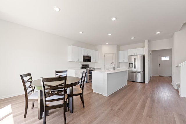 1391 Aspen Ln, Pingree Grove, IL 60140 - kitchen featuring appliances with stainless steel finishes, a kitchen island with sink, white cabinetry, light wood-style flooring, and recessed lighting