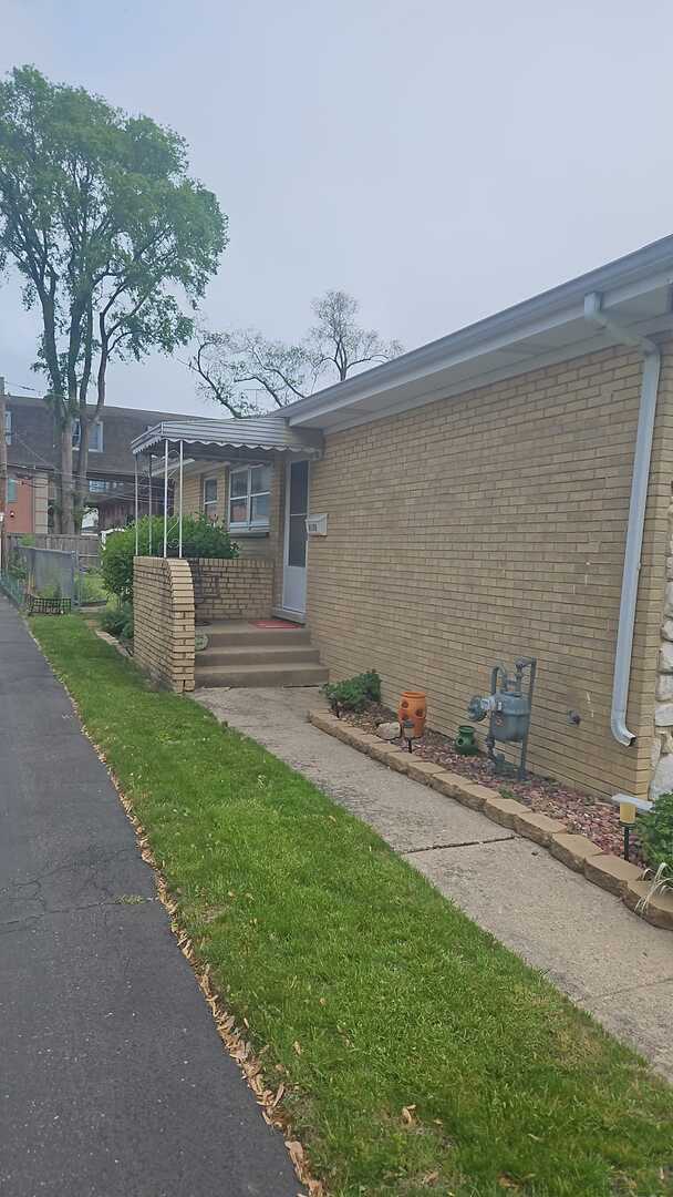 6140 Elm St, Morton Grove, IL 60053 - view of side of home featuring brick siding and a yard