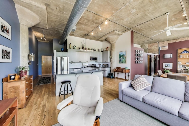 1800 W Roscoe St Unit 432, Chicago, IL 60657 - living room with track lighting, a ceiling fan, light wood-style floors, and a towering ceiling