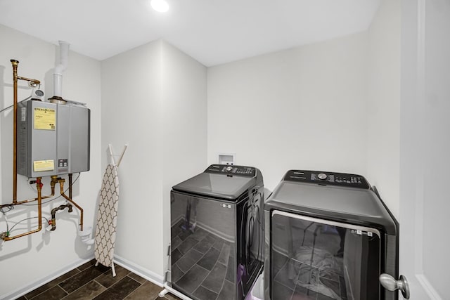 laundry area featuring independent washer and dryer, water heater, wood tiled floors, and baseboards
