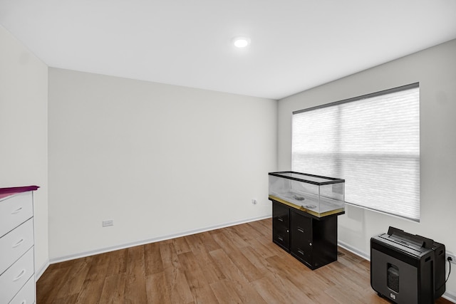 unfurnished office with light wood-style flooring, baseboards, and recessed lighting
