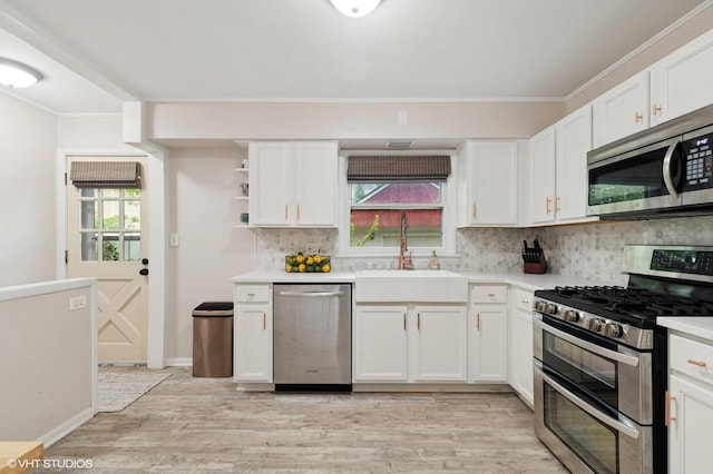 431 Elm Ave, Geneva, IL 60134 - kitchen featuring stainless steel appliances, a sink, light wood-type flooring, white cabinetry, and ornamental molding