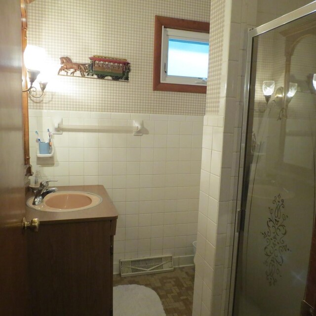 206 Vermont St, Momence, IL 60954 - full bathroom with vanity, toilet, a shower stall, and tile walls