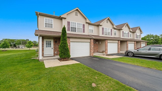 677 Southtowne Dr Unit 1, Belvidere, IL 61008 - view of property featuring an attached garage, driveway, brick siding, and a front yard