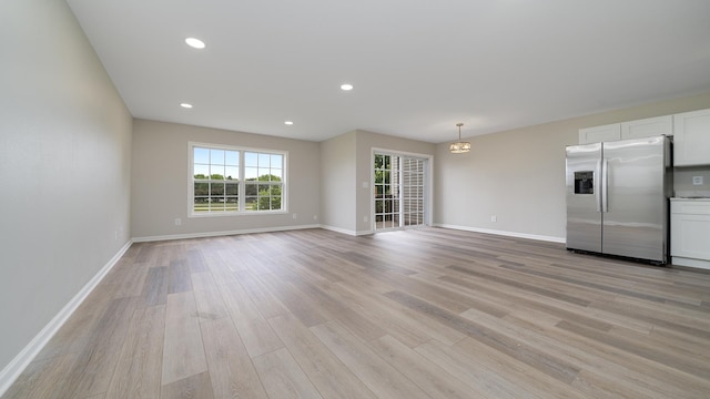 677 Southtowne Dr Unit 1, Belvidere, IL 61008 - unfurnished living room featuring light wood-type flooring, baseboards, and recessed lighting