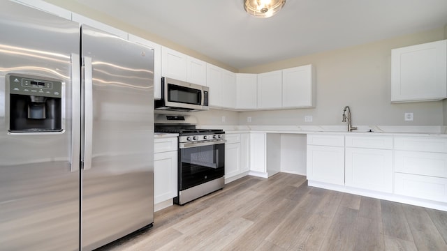 677 Southtowne Dr Unit 1, Belvidere, IL 61008 - kitchen with stainless steel appliances, light wood finished floors, a sink, and white cabinetry