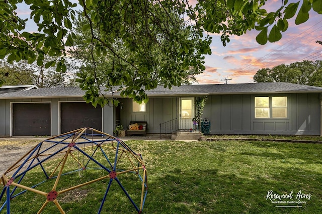 125 E Second S St, Chebanse, IL 60922 - ranch-style home with board and batten siding, a garage, dirt driveway, and a front lawn