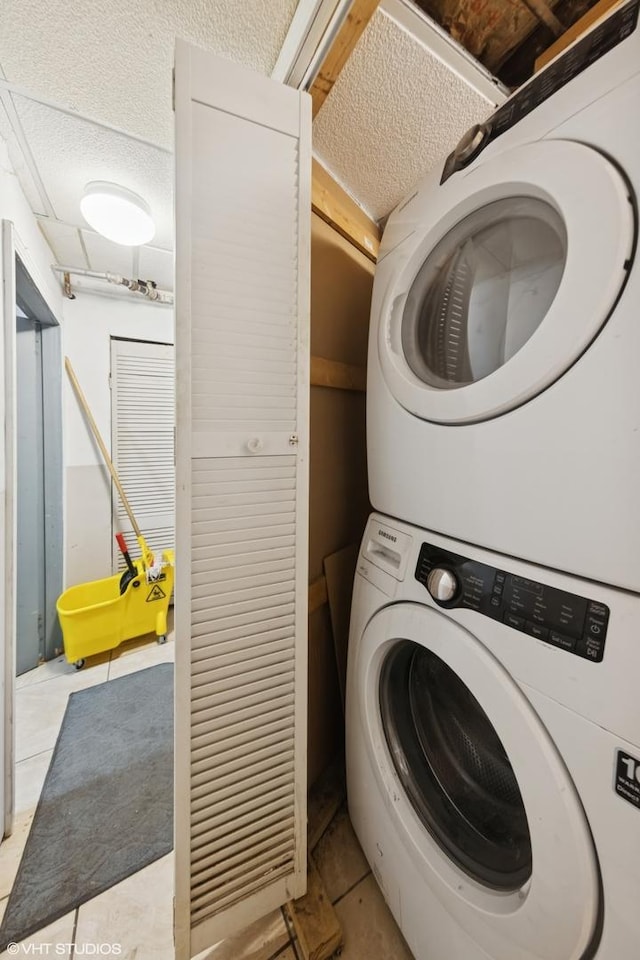 5351 N Kimball Ave, Chicago, IL 60625 - washroom featuring estacked washer and dryer, light tile patterned floors, and a textured ceiling