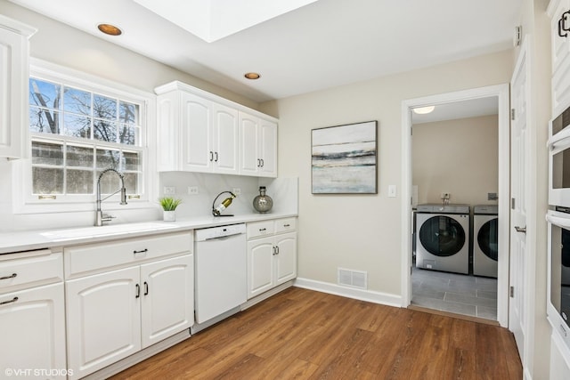 2028 Creekside Dr, Wheaton, IL 60189 - kitchen featuring white dishwasher, a sink, washer and dryer, light wood-type flooring, and baseboards