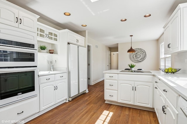 2028 Creekside Dr, Wheaton, IL 60189 - kitchen with white appliances, a peninsula, recessed lighting, light wood-style floors, and white cabinetry
