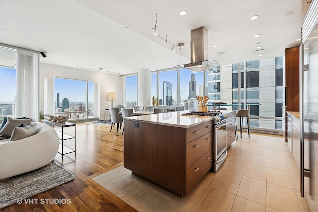 340 E Randolph St Unit 4806, Chicago, IL 60601 - kitchen with stainless steel gas stove, open floor plan, a view of skyline, island range hood, and a center island