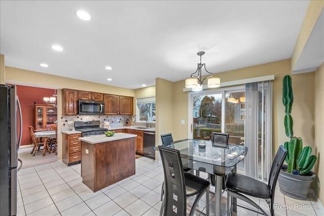 553 S Haverhill Ln, South Elgin, IL 60177 - kitchen with appliances with stainless steel finishes, a sink, a kitchen island, light countertops, and tasteful backsplash