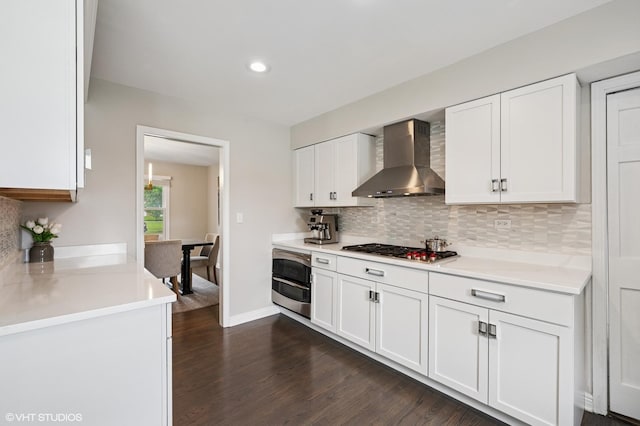 4141 Rutgers Ln, Northbrook, IL 60062 - kitchen with wall chimney range hood, appliances with stainless steel finishes, backsplash, dark wood finished floors, and white cabinets