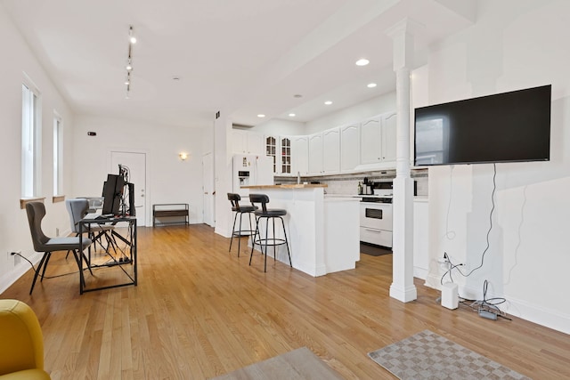 918 W 35th Pl, Chicago, IL 60609 - kitchen featuring white appliances, ornate columns, a breakfast bar, glass insert cabinets, and white cabinetry