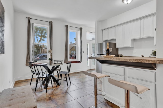 918 W 35th Pl, Chicago, IL 60609 - kitchen with white cabinets, freestanding refrigerator, tile patterned floors, and baseboards