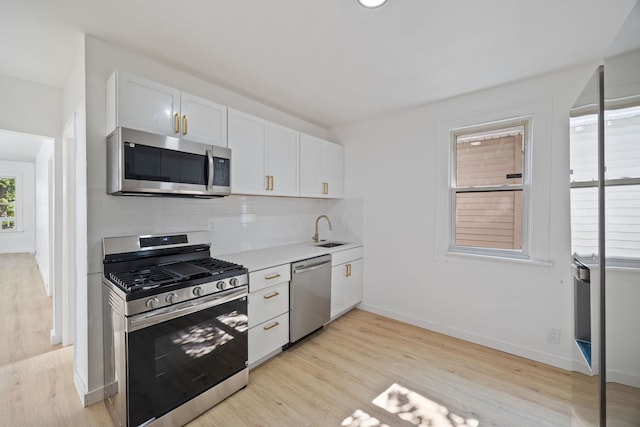 17 E 100th Pl, Chicago, IL 60628 - kitchen featuring stainless steel appliances, decorative backsplash, white cabinets, and light wood-style flooring