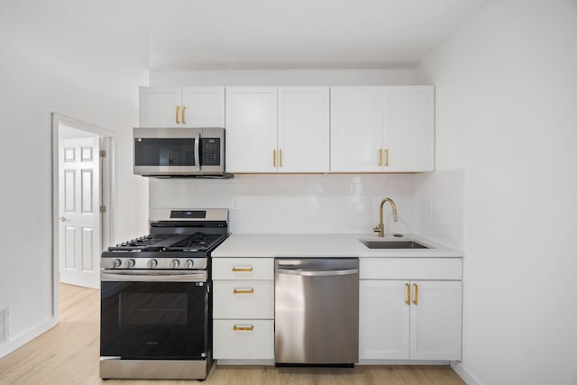 17 E 100th Pl, Chicago, IL 60628 - kitchen featuring appliances with stainless steel finishes, light wood finished floors, tasteful backsplash, and white cabinets